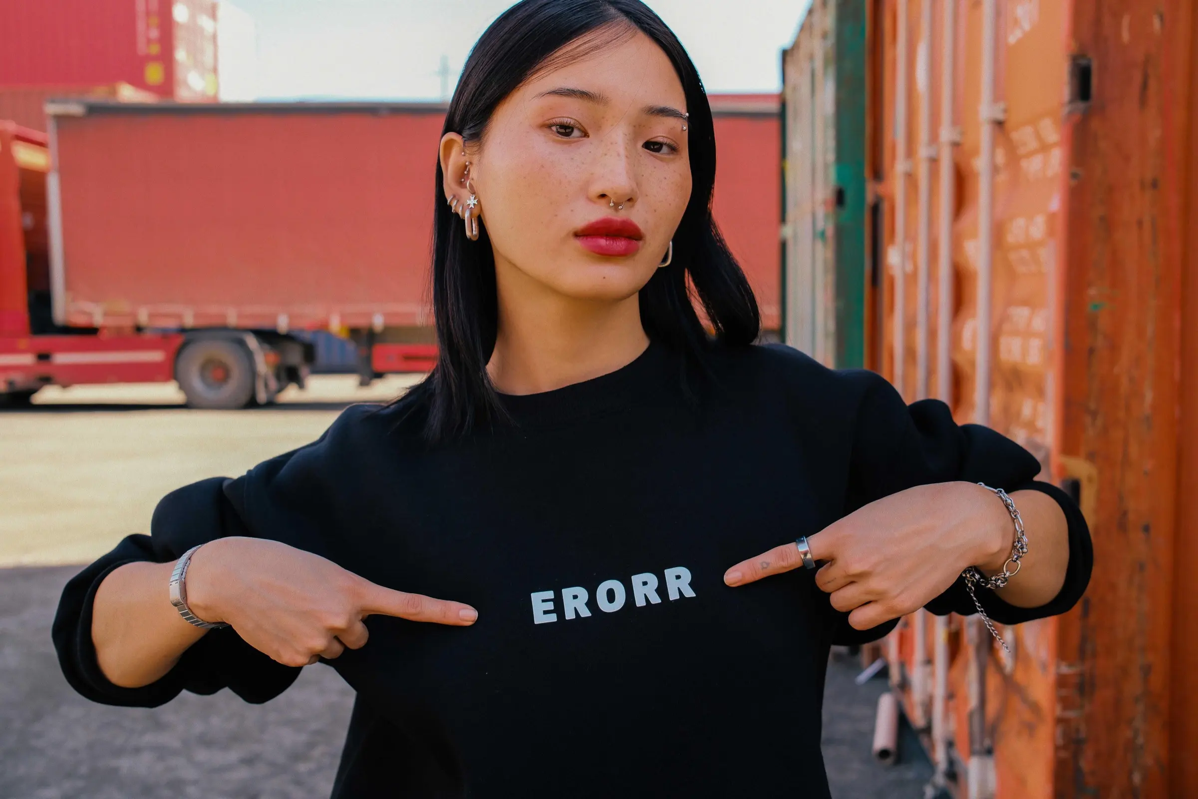 Model pointing at the ERORR print on a black sweatshirt
