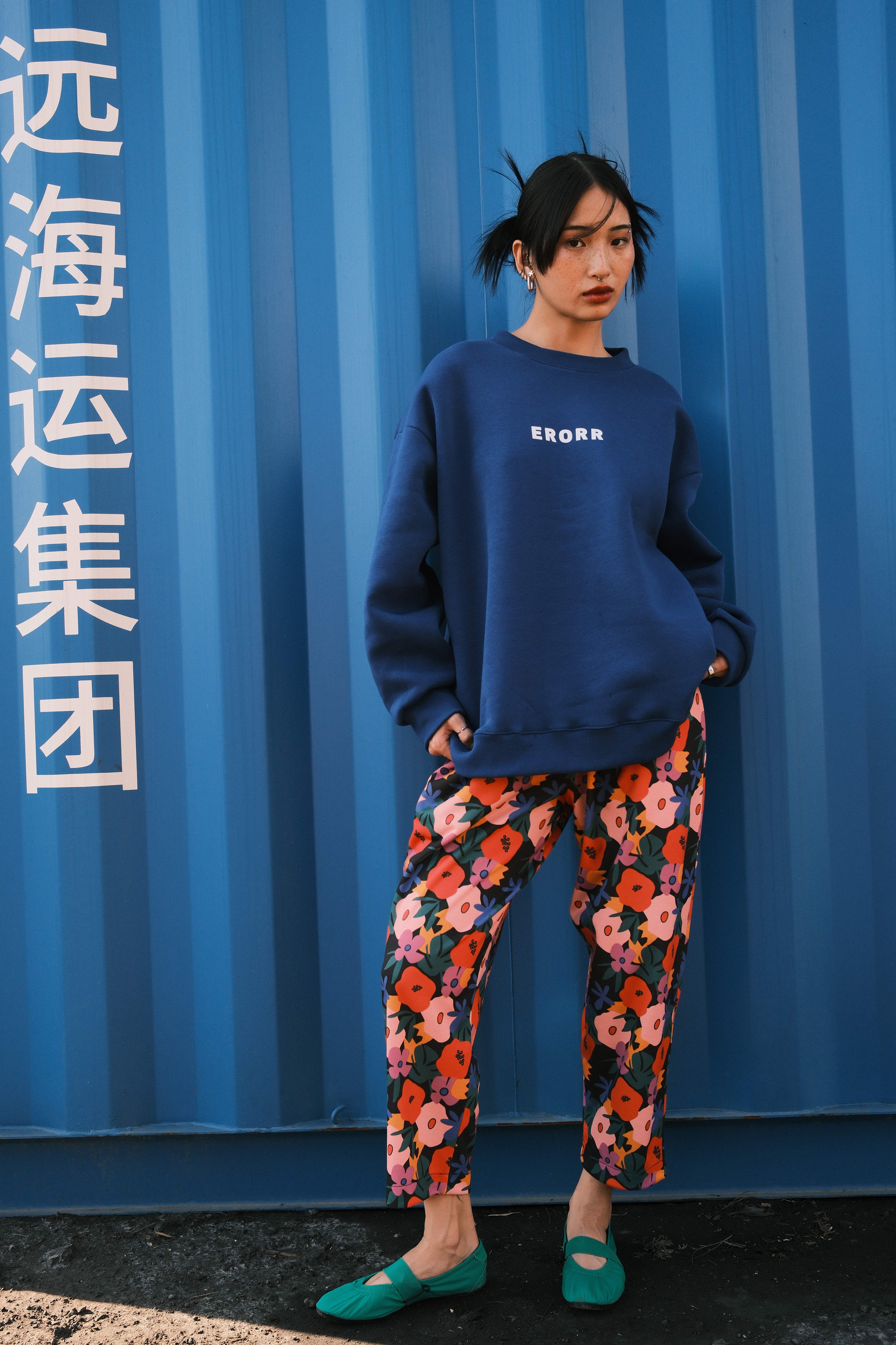Model in a matching floral track set against a green container