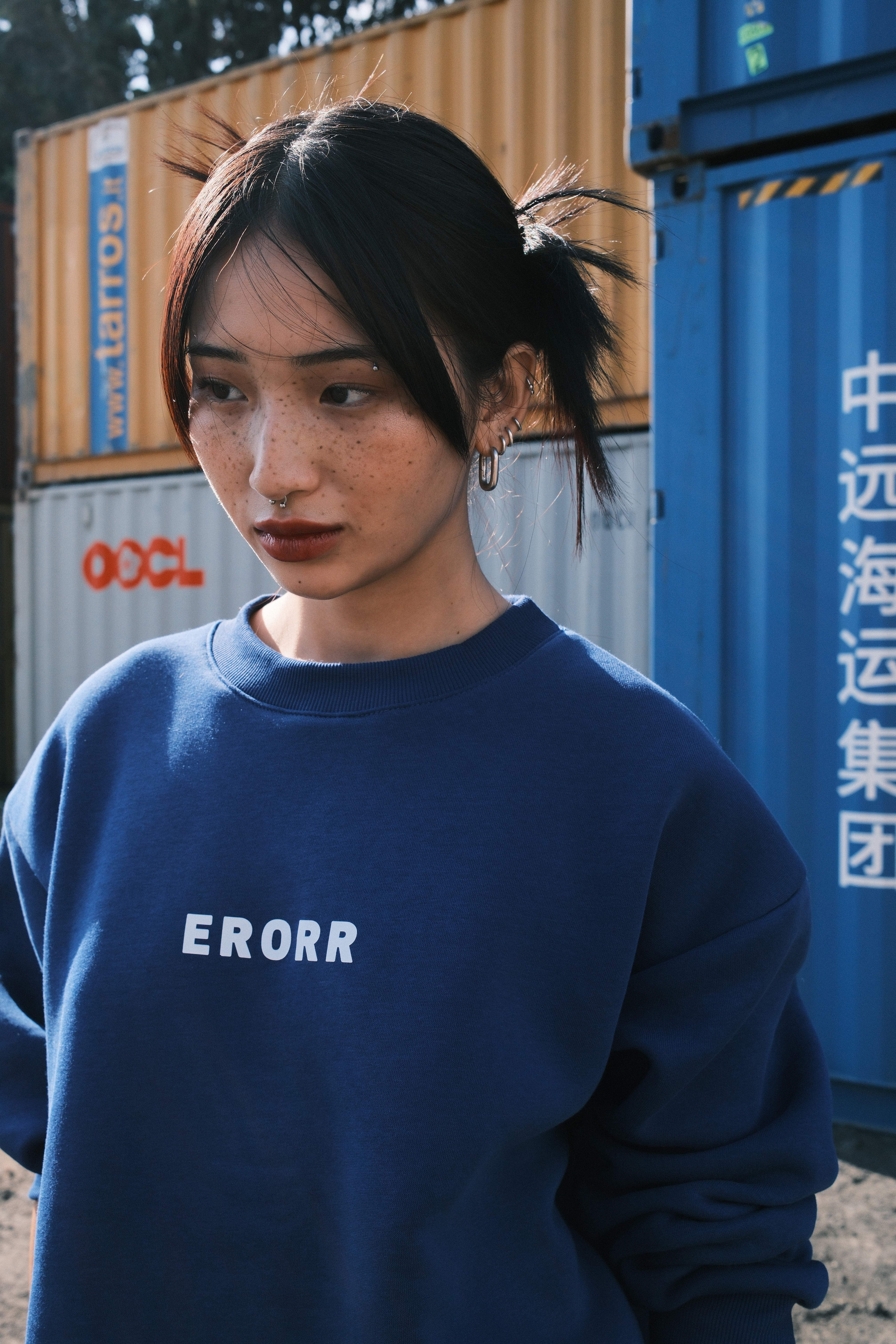 Model pointing at the ERORR print on a black sweatshirt